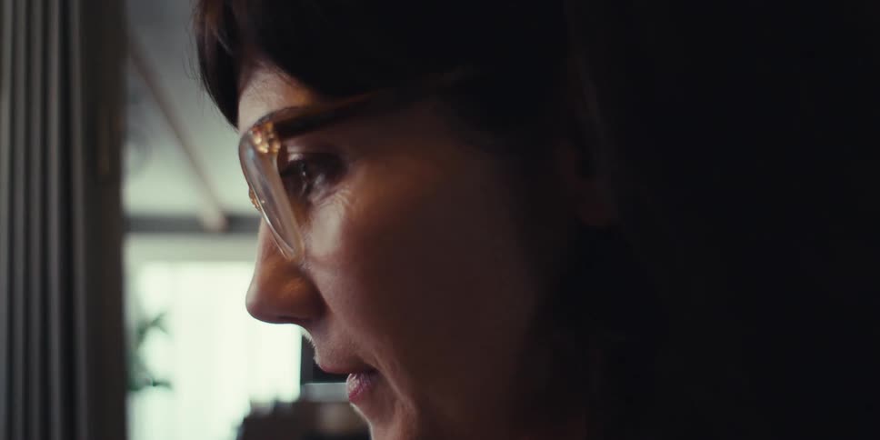 A woman smiles while looking at something