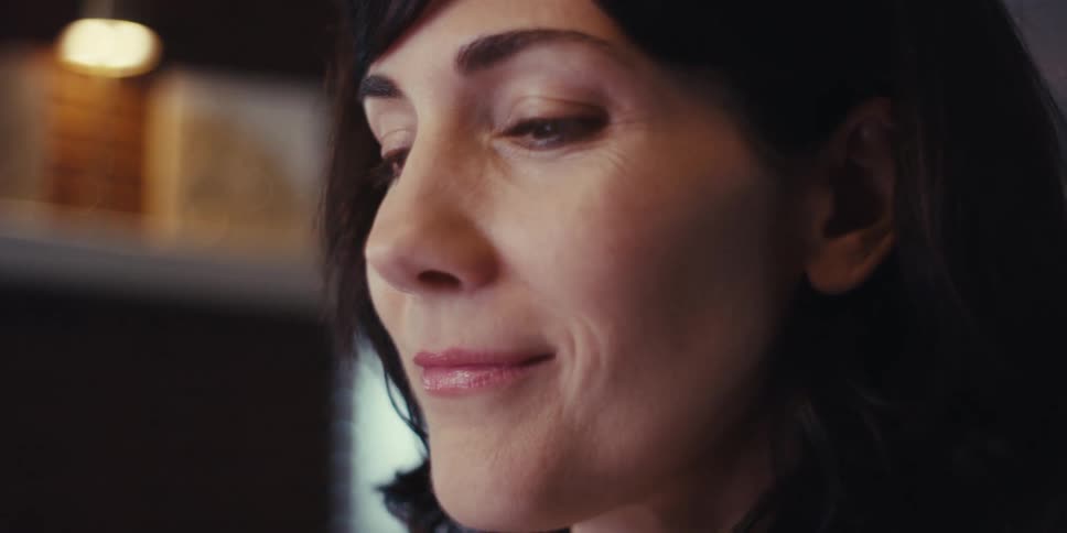 A woman smiles while using her computer