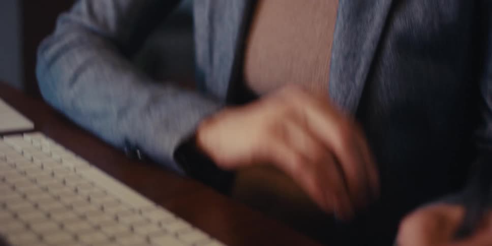 Woman sitting down taking notes on a pink notepad