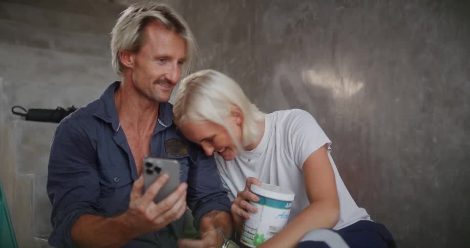A couple laugh while looking at the phone