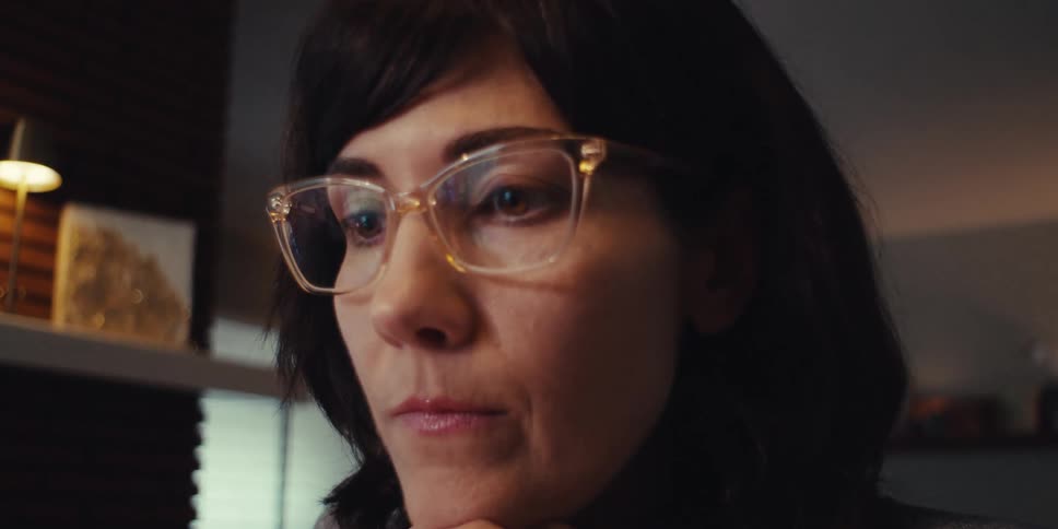 A woman has her hands on her chin while thinking about something