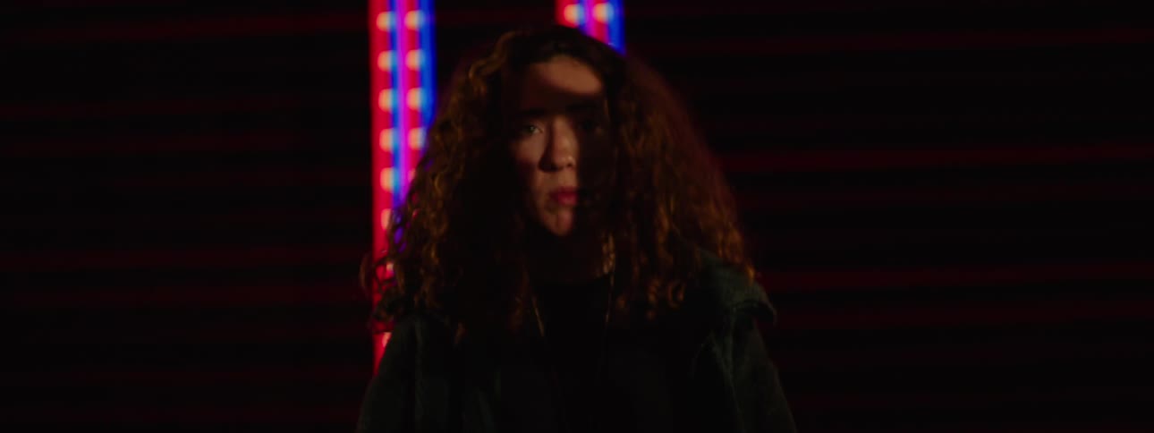 Portrait of a curly haired woman with a background of an abstract screen displaying lights