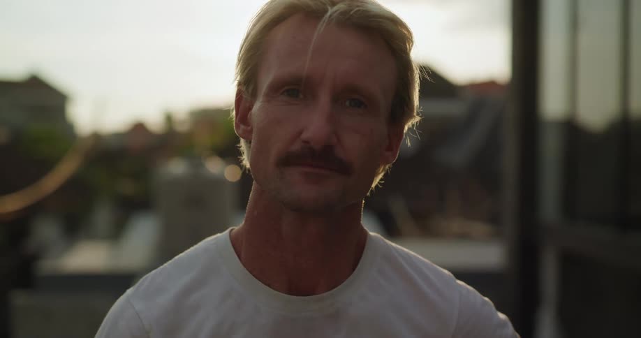 Blond man with mustache taking off his goggles
