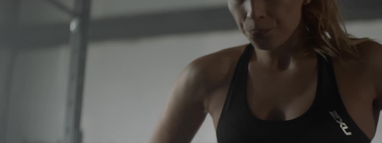 A woman is in a gym stretching