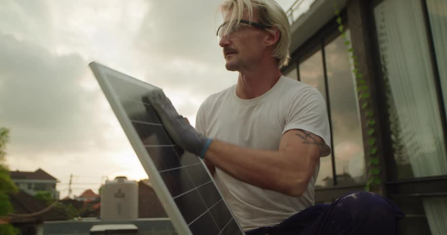 A man wipes off the solar panel