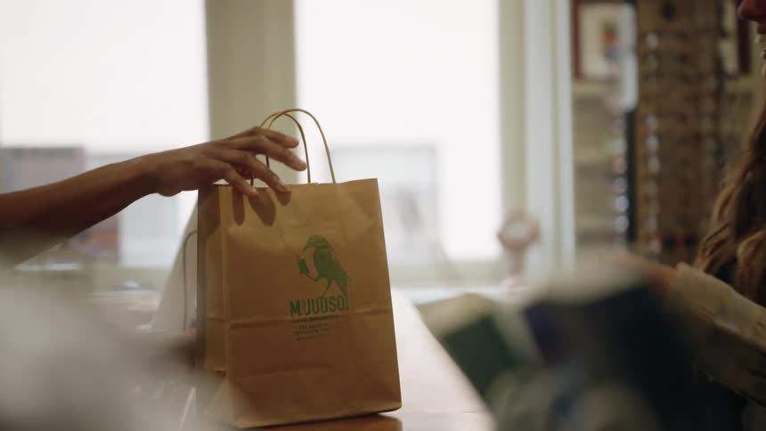 Woman picking up a shopping bag in a commercial establishment