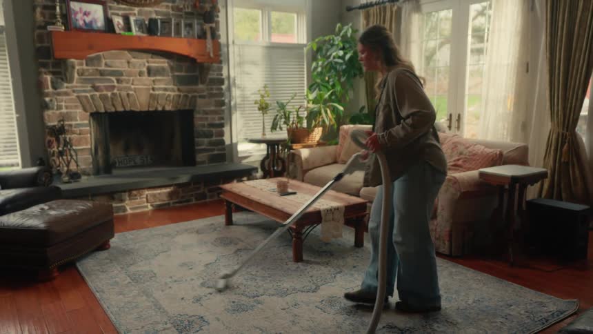 Woman vacuuming living room carpet