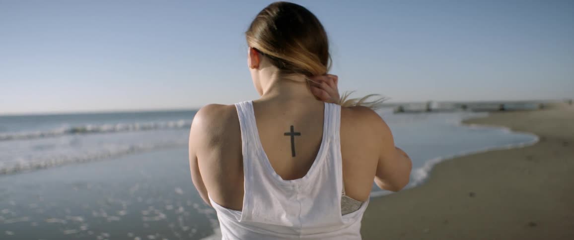 Woman standing at the edge of a beach