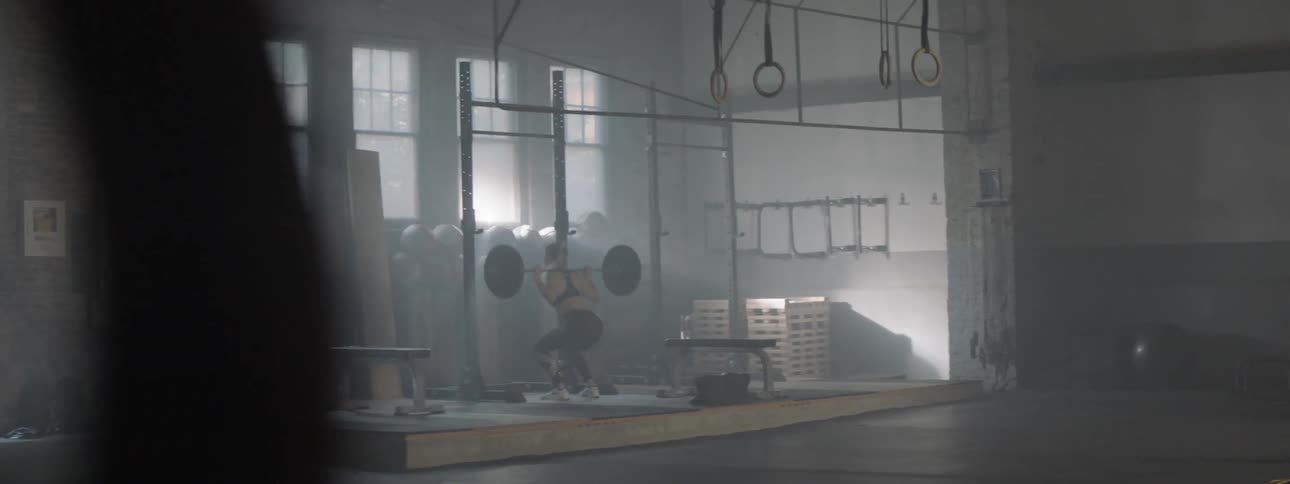 A woman lifting weights inside of a building