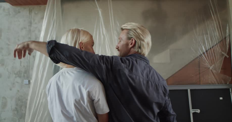 Couple inside a house under construction hugging and kissing