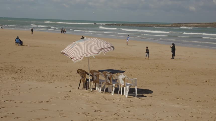 People are walking and playing on the beach