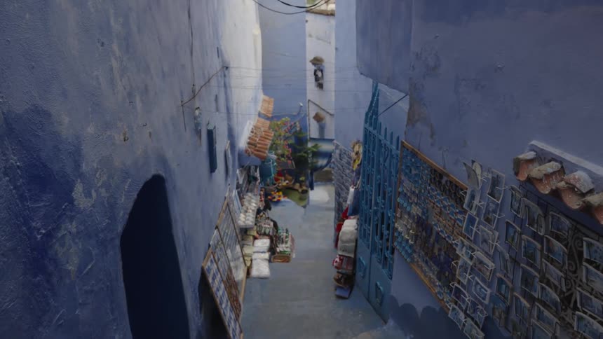 View of artwork in a narrow alley between two buildings painted in blue