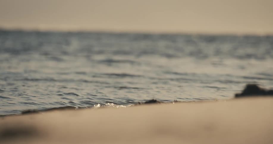 The small waves are hitting the sand
