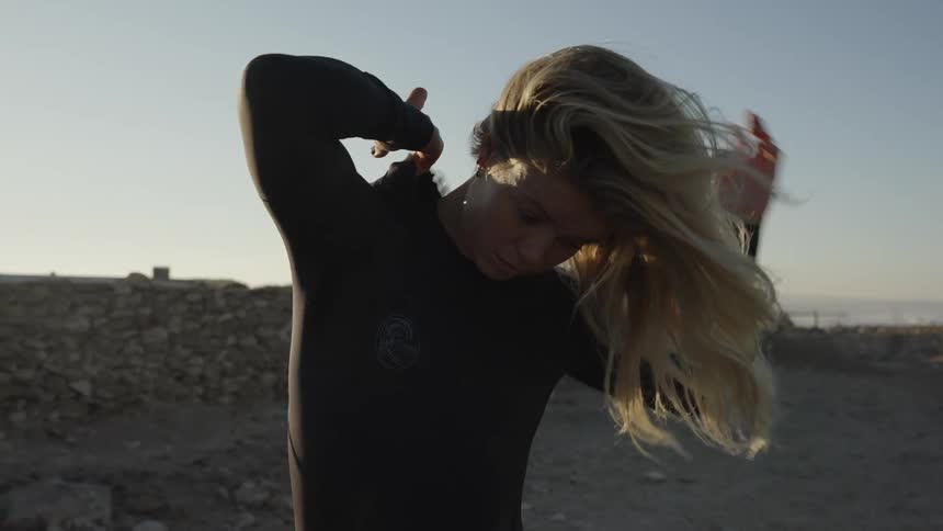 Woman taking off wetsuit