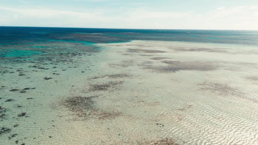 Aerial view of shallow ocean waters and coral reefs