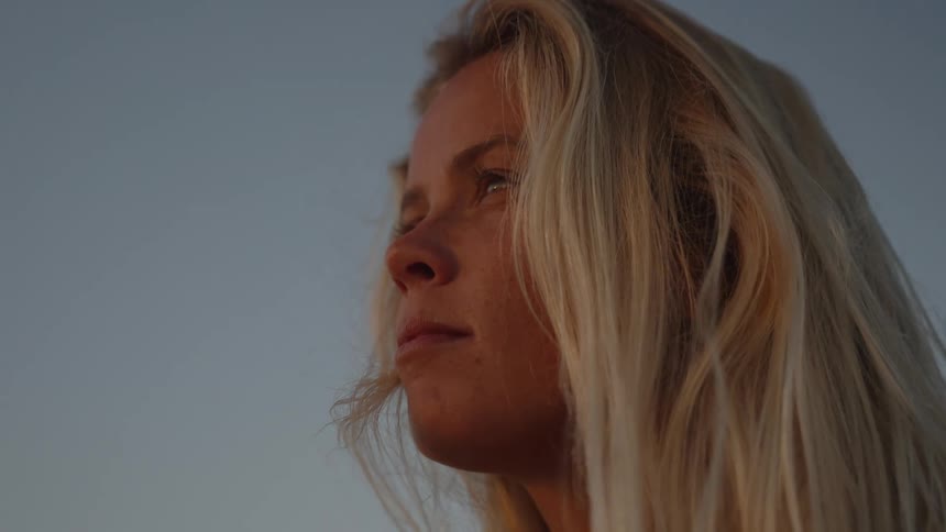 Blonde woman outdoors against a blue sky