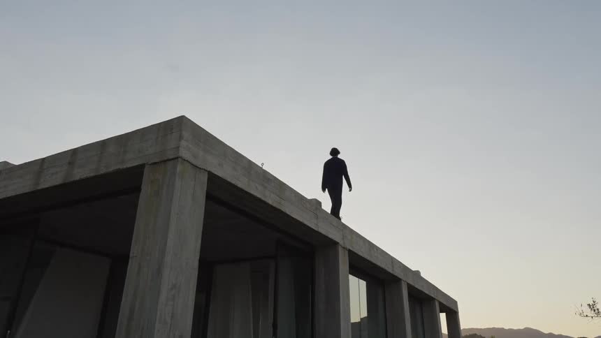 A man walks on the roof of the home