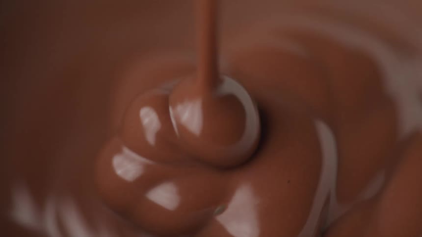 Smooth chocolate mixture reflects the light while being poured