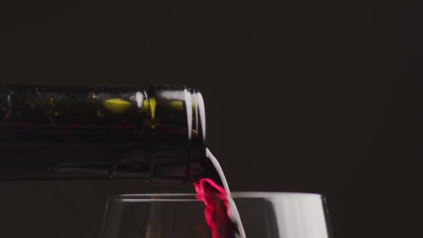 A glass of red wine is poured