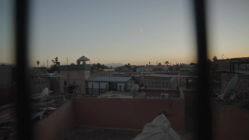 Panorama of a suburb seen through a window grate on a dawn sky