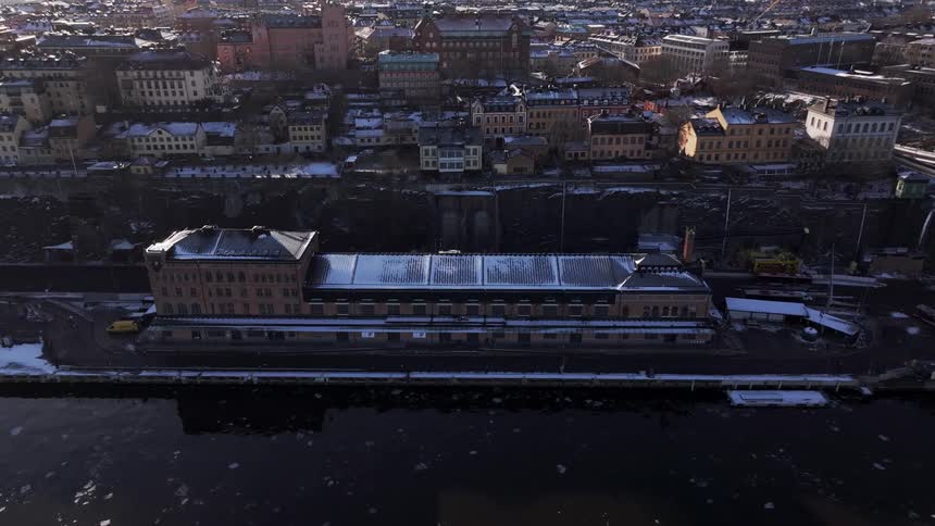 Aerial view of a snowy city on the edge of a sea canal