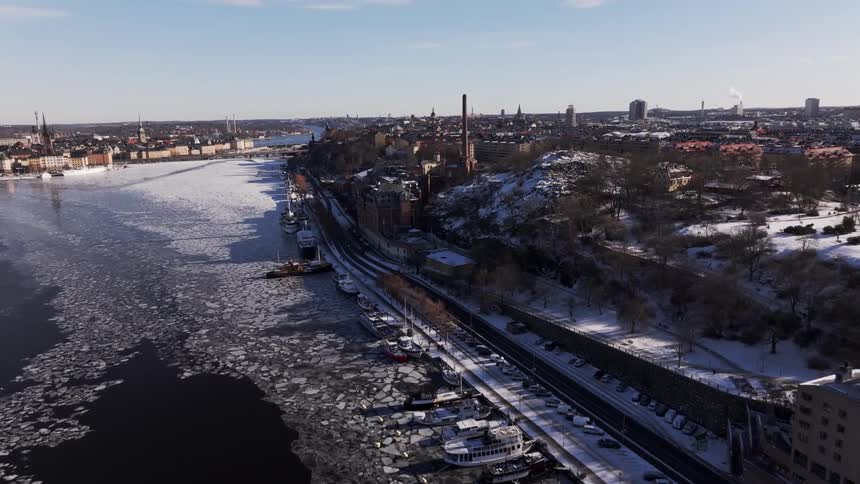 Aerial of a boat marina on an icy river in an urban area