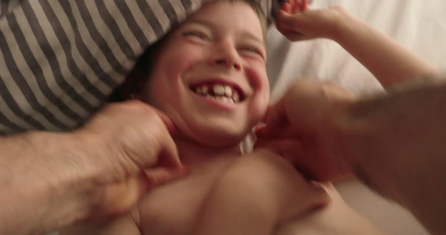 A father is tickling his son