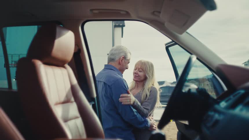 Man hugging a woman and saying goodbye affectionately and then getting into the car