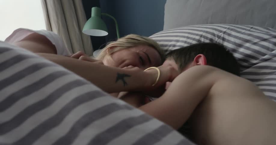 Mother and son playing on the bed indoor during the day