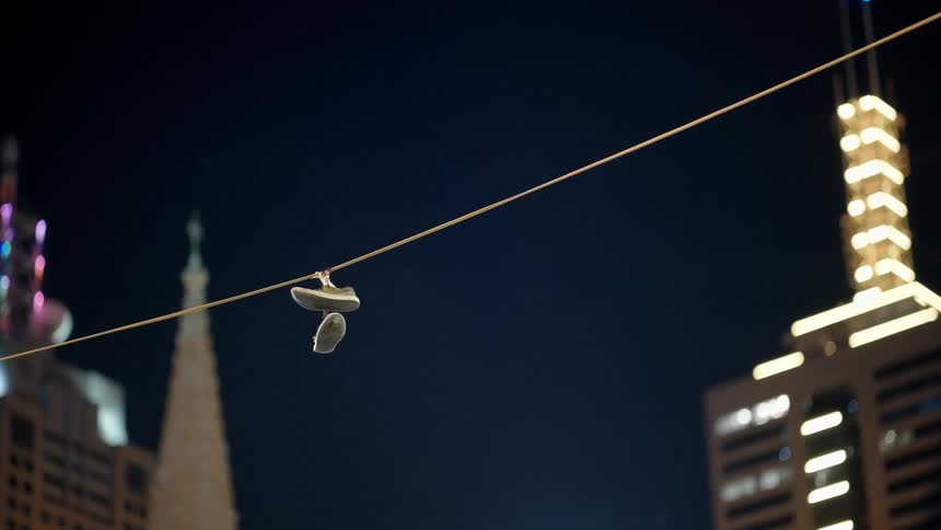 Shoes hang from a clothesline in the city