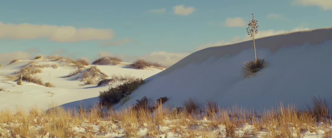 Snow covers desert hills on a partly sunny winter day