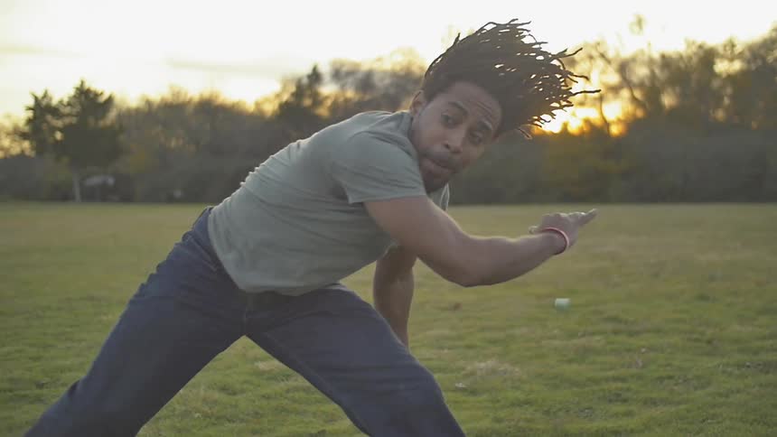 Man jumping and twirling in a field