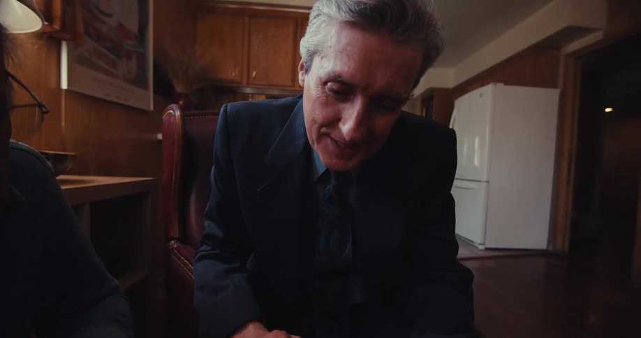 Two people discuss a trading strategy chart with one pointing and the other listening and reacting