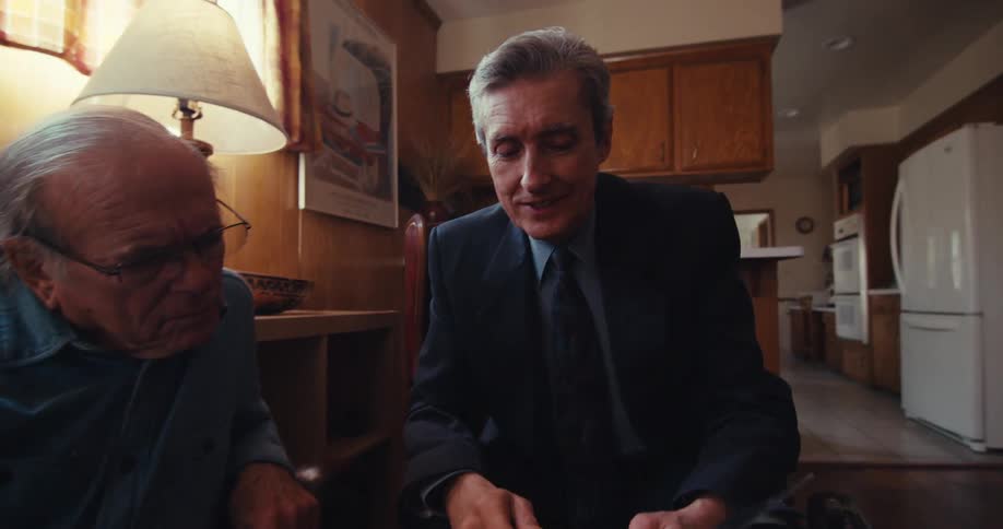 A man pulls out a form and pen asking a man to sign