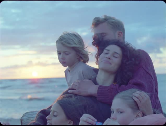 A mother passes out candy to her family on the beach