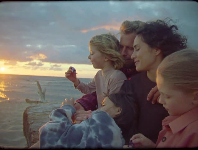 A family hug while watching the sunrise on the beach