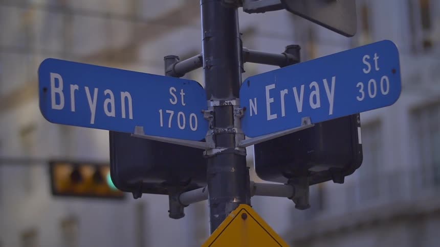 A sign in a city is near an intersection