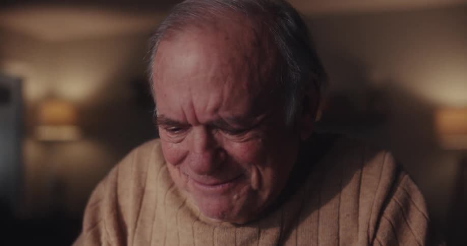A man is laughing while typing on his computer