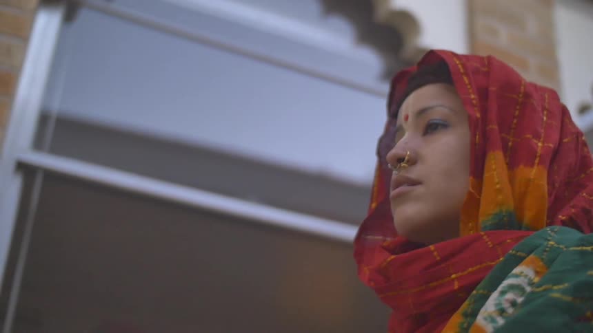 A woman in a sari is walking outside during daylight