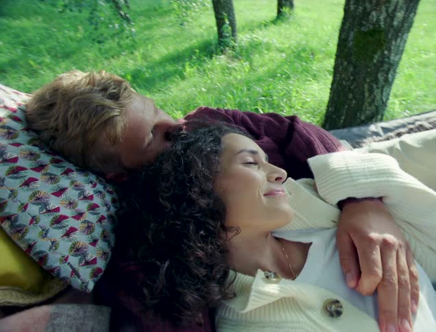 A couple hug while laying on a hammock