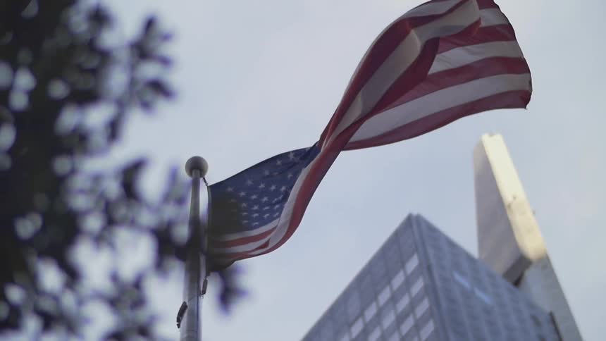 A u.s. flag is blowing in the wind during the day