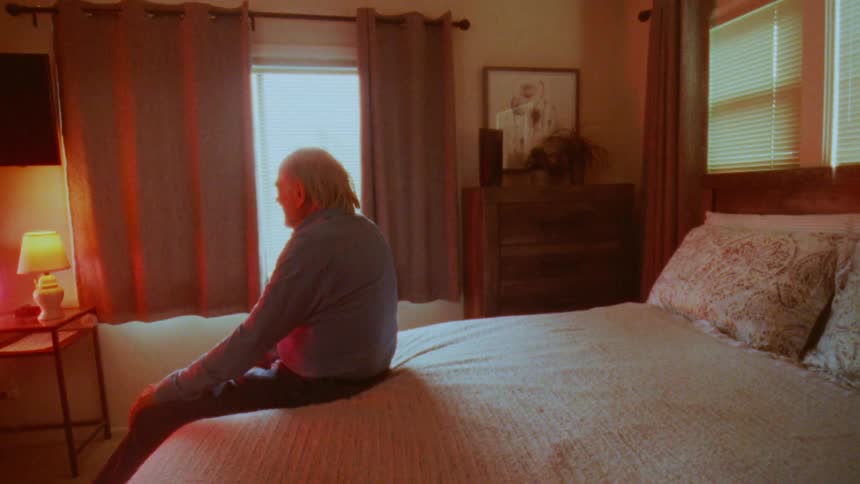 A man claps his hands while watching television