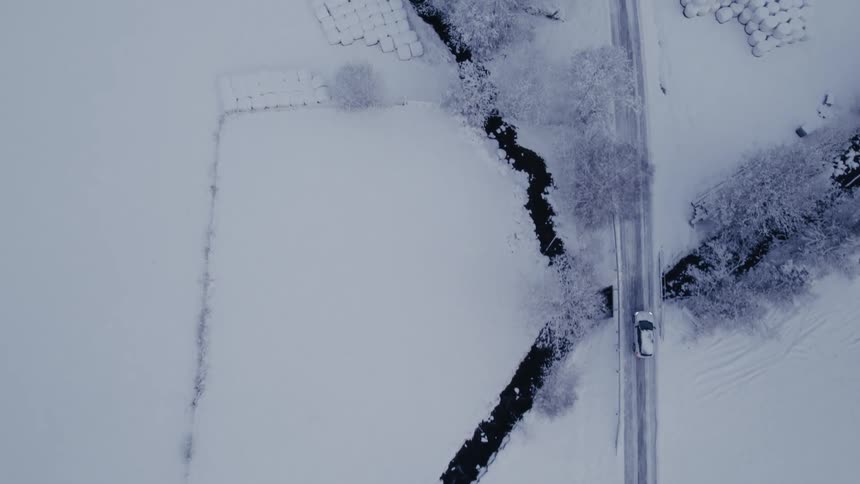 The car drives on the snow filled road