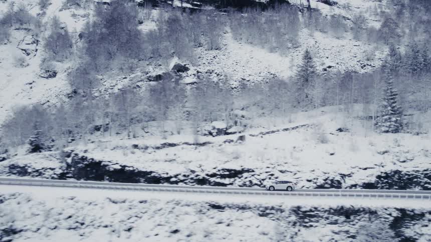 An suv on a freeway through a mountainous coastal area