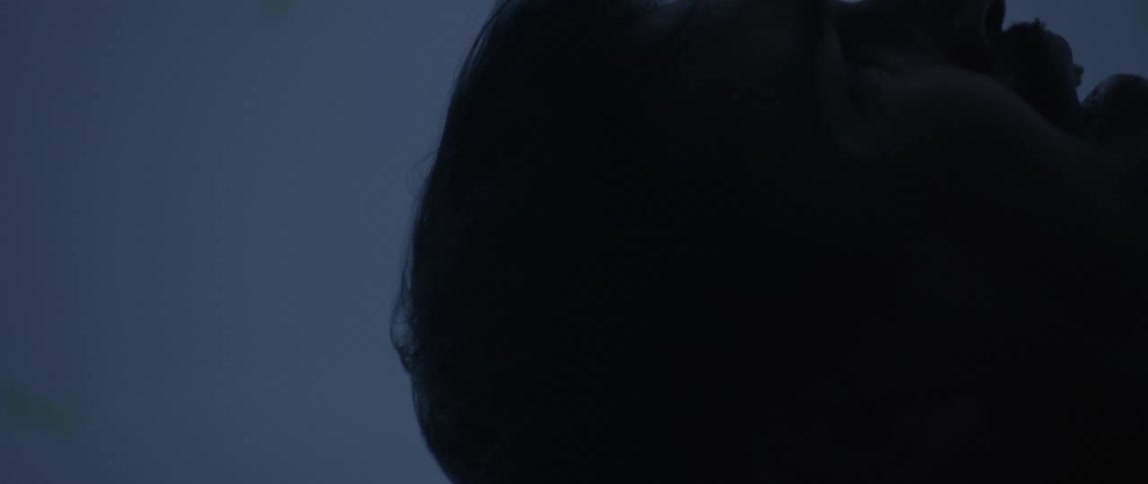 Close up of a man with hair flowing hands raised as if plummeting from great heights but he is actually in a dimly lit motion capture studio