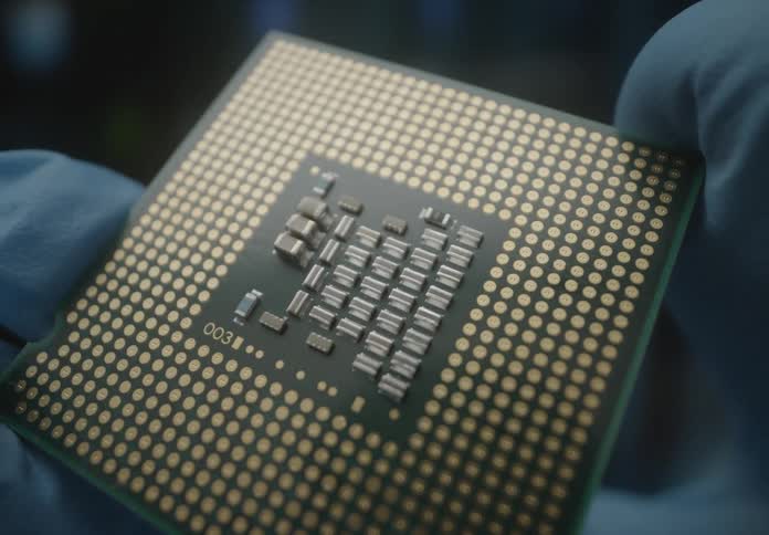 A person is holding a small computer chip