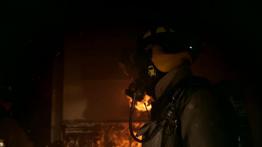 Firefighter inside a burning house at night