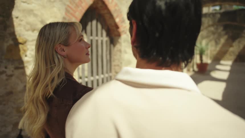 A man and a woman walking along a corridor observing the arched rock walls