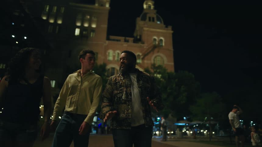 Friends walk past the building while talking