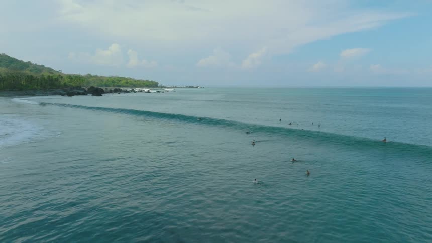 Aerial view of people swimming and surfing in the ocean